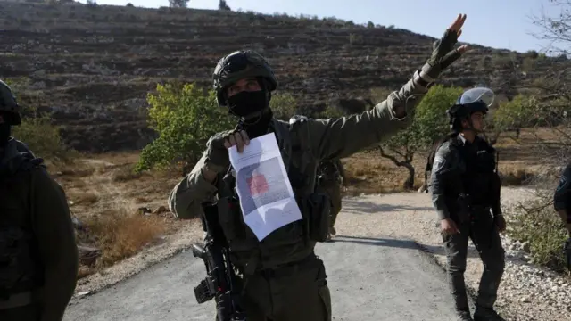 قوات إسرائيلية أثناء حصاد الزيتون قرب الخليل بالضفة الغربية