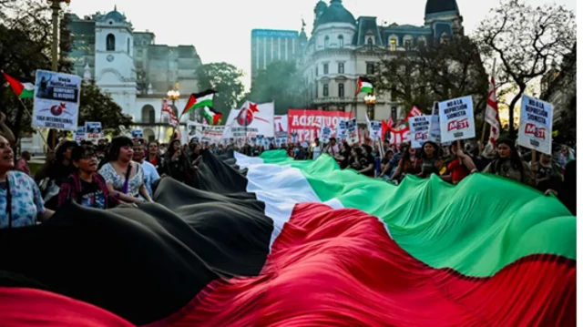 مؤيدون للفلسطينيين يحملون علماً فلسطينياً ضخماً خلال مظاهرة تضامناً مع "أسطول الصمود العالمي" وغزة، في بوينس آيرس في الأرجنتين