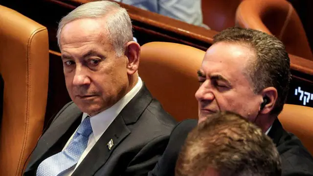 رئيس الوزراء الإسرائيلي بنيامين نتنياهو وإلى جواره وزير الدفاع إسرائيل كاتس، كلاهما يرتديان لباساً رسمياً.