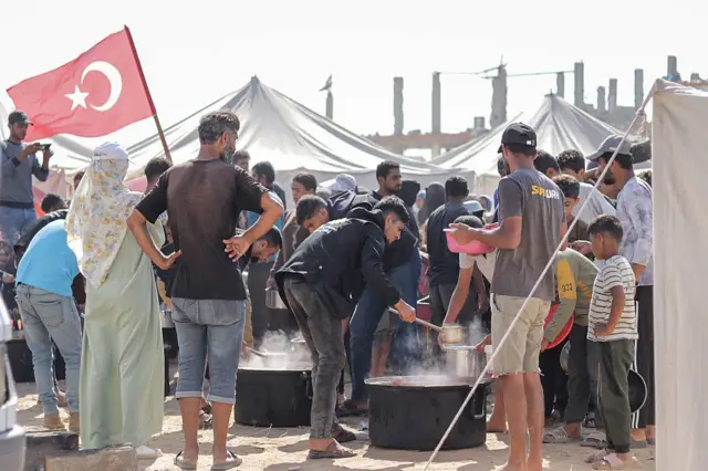 جمعية عثمان أوغلو الخيرية التركية للتضامن توزع وجبات ساخنة على الفلسطينيين في مخيم النصيرات للاجئين في وسط قطاع غزة في 1 نوفمبر/تشرين الثاني 2025.