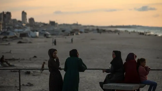 يقضي الفلسطينيون النازحون وقتهم على الشاطئ مقابل خيامهم الممتدة على طول ميناء غزة، في غزة، في 13 نوفمبر/تشرين الثاني 2025. 