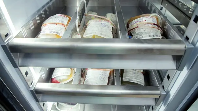 وحدات دم في أكياس طبية، داخل مكان تخزين معدنية.