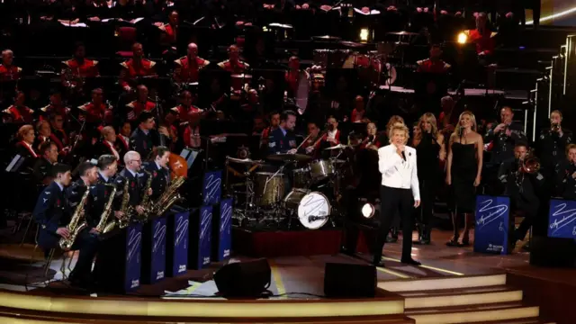 السير رود ستيوارت برفقة الفرقة الموسيقية الكبيرة التابعة للقوات الجوية البريطانية