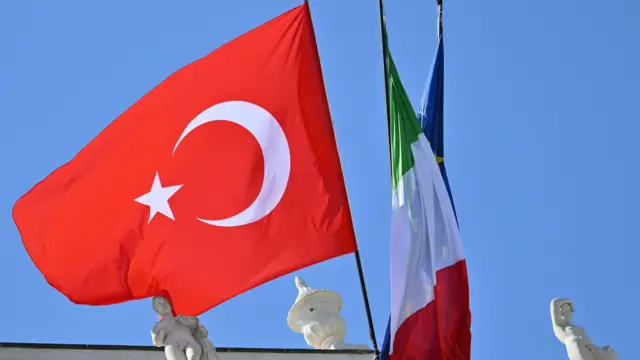 تُظهر هذه الصورة علمًا تركيًا يرفرف بجانب علمي إيطاليا والاتحاد الأوروبي خلال زيارة الرئيس التركي إلى فيلا دوريا بامفيلي بروما في 29 أبريل/نيسان 2025. 