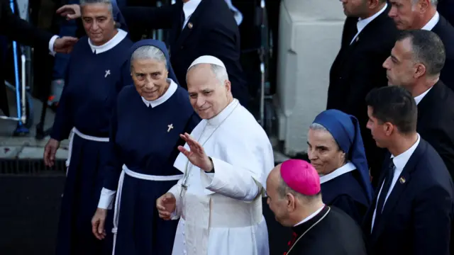 البابا لاون الرابع عشر يلوح بيده أثناء زيارته لمستشفى دي لا كروا للأمراض النفسية، خلال رحلته الرسولية الأولى، في جل الديب، لبنان، 2 ديسمبر/كانون الأول 2025. 
