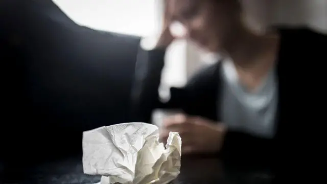 منديل ورقي مستخدَم على طاولة أمام شخص