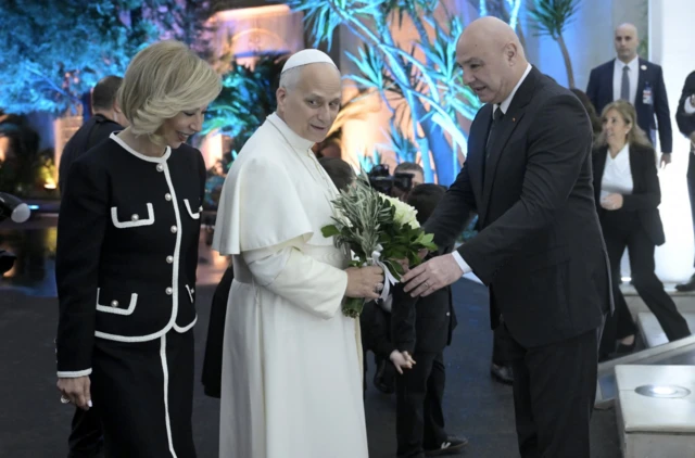 الرئيس اللبناني جوزف عون (يمين) وزوجته نعمت (يسار)، سيدة لبنان الأولى، يرحبان بالبابا لاون الرابع عشر (وسط) لدى وصوله إلى القصر الرئاسي في بعبدا، شرق بيروت، لبنان