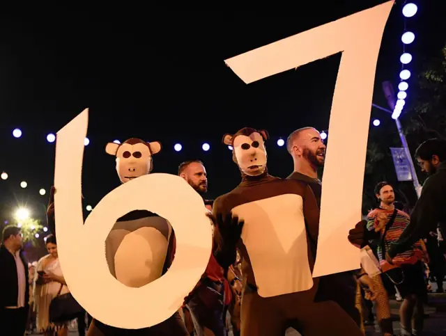 محتفلون بملابس تنكّرية يرفعون إشارة "6–7" خلال كرنفال الهالووين في ويست هوليوود لعام 2025، في 31 أكتوبر/تشرين الأول 2025، في مدينة ويست هوليوود، كاليفورنيا.