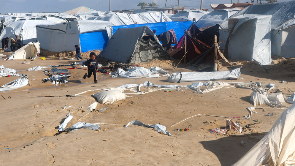 235 ألف شخص تضرروا من منخفض “بايرون” الجوي في قطاع غزة طفل فلسطيني نازح يركض بين الخيام المتضررة في مخيم على شاطئ خان يونس، جنوب قطاع غزة، بعد أن غمرته مياه البحر المتصاعدة خلال عاصفة شتوية، وذلك في 28 كانون الأول 2025. (رويترز)