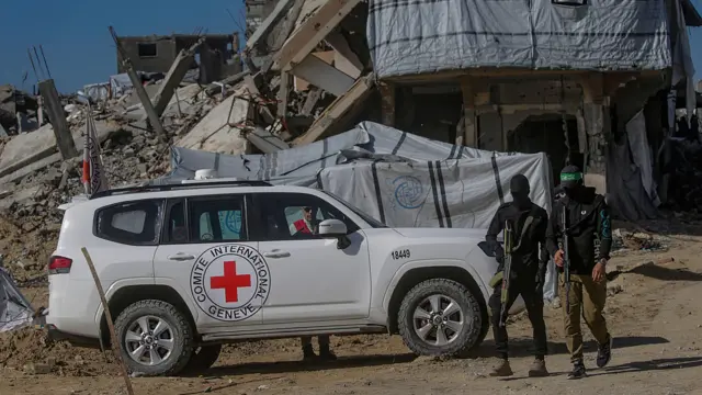 مقاتلون من كتائب القسام، الجناح العسكري لحركة حماس، يقفون حراساً أثناء بحثهم عن جثث رهائن إسرائيليين إلى جانب عمال الصليب الأحمر في مخيم جباليا للاجئين في شمال قطاع غزة، 1 ديسمبر 2025.