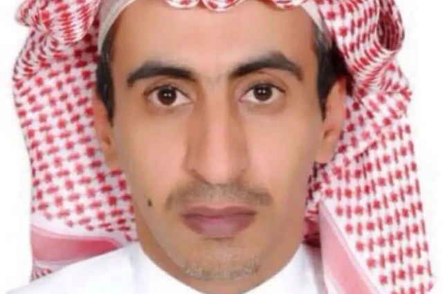 الصحفي السعودي تركي الجاسر، ينظر إلى الكاميرا ويظهر وجهه فقط، ويرتدي عقالاً يمزج بين اللونين الأبيض والأحمر يغطي رأسه.