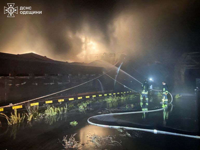 رجال إنقاذ أوكرانيون يحاولون إخماد حريق بسفينة شحن مدنية بعد هجوم جوي على ميناء في أوديسا، 23 ديسمبر/كانون الأول 2025 