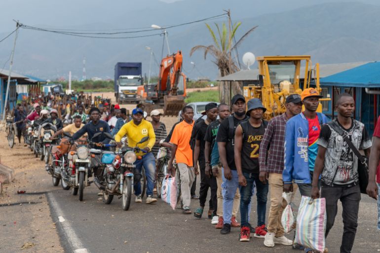 Burundian citizens who work in Uvira, Democratic Republic of the Congo, and could not cross back into their home country due to fighting, cross the border into Burundi, Sunday, Dec. 14, 2025. (AP Photo/Moses Sawasawa)