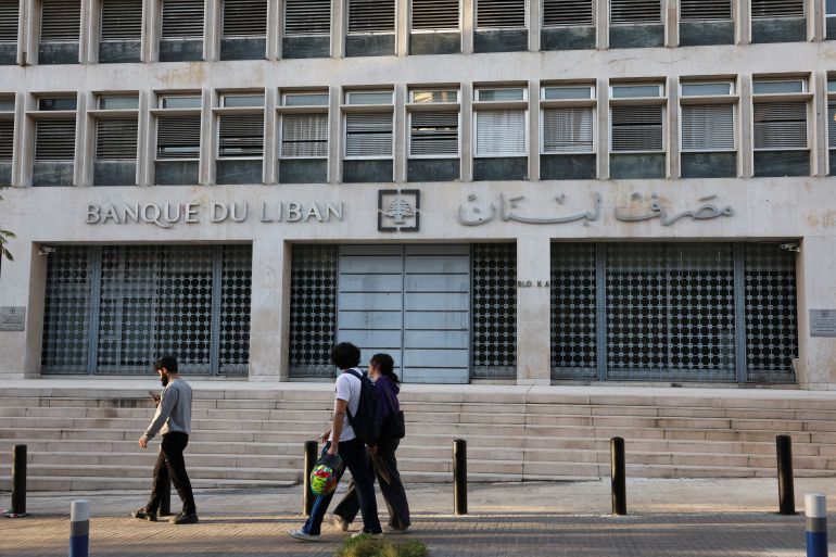People walk past Lebanon's Central Bank building in Beirut, Lebanon, March 27, 2025. REUTERS/Mohamed Azakir