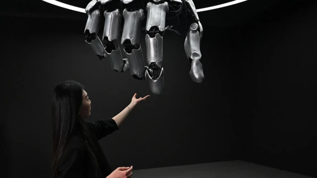 فتاة تلمس يدا آلية ضخمة