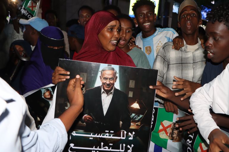 epa12615933 A woman holds a poster depicting Israeli Prime Minister Benjamin Netanjahu as demonstrators gather during an anti-Israel protest in Mogadishu, Somalia, 28 December 2025. This comes a day after Israel announced that it has recognized the breakaway Somali region of Somaliland as a sovereign and independent nation and established full diplomatic ties. EPA/Said Yusuf Warsame
