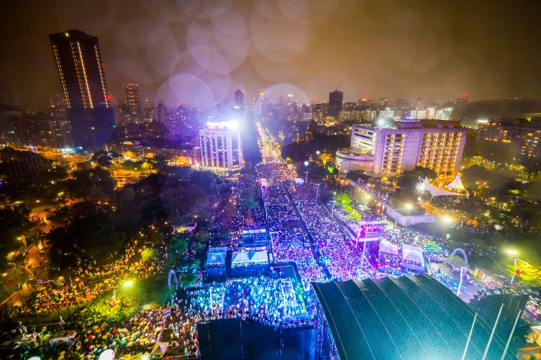 epa12619323 A general view of the crowd at a concert during a downpour of rain while waiting for the fireworks from Taipei 101 skyscraper, during the New Year's Eve celebrations in Taipei, Taiwan, 31 December 2025. EPA/RITCHIE B. TONGO