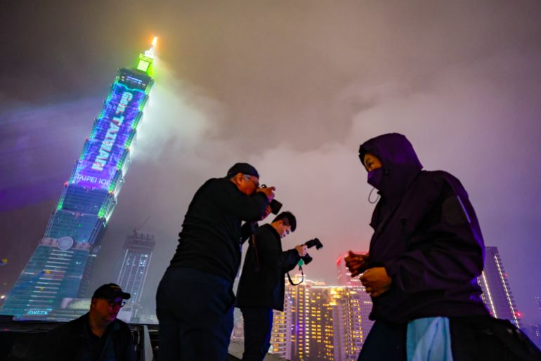 epa12619324 Journalists take photos of a crowd waiting for the fireworks from Taipei 101 skyscraper, during the New Year's Eve celebrations in Taipei, Taiwan, 31 December 2025. EPA/RITCHIE B. TONGO