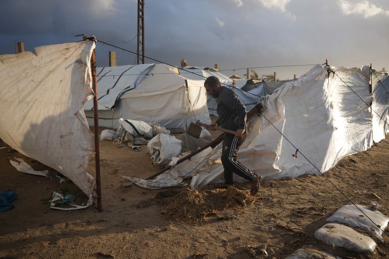 Khaled Abu Jazar, 53, reinforces his tent after it was damaged by stormy weather at a tent camp in Deir al-Balah, in the central Gaza Strip, Friday, Jan. 9, 2026. (AP Photo/Abdel Kareem Hana)