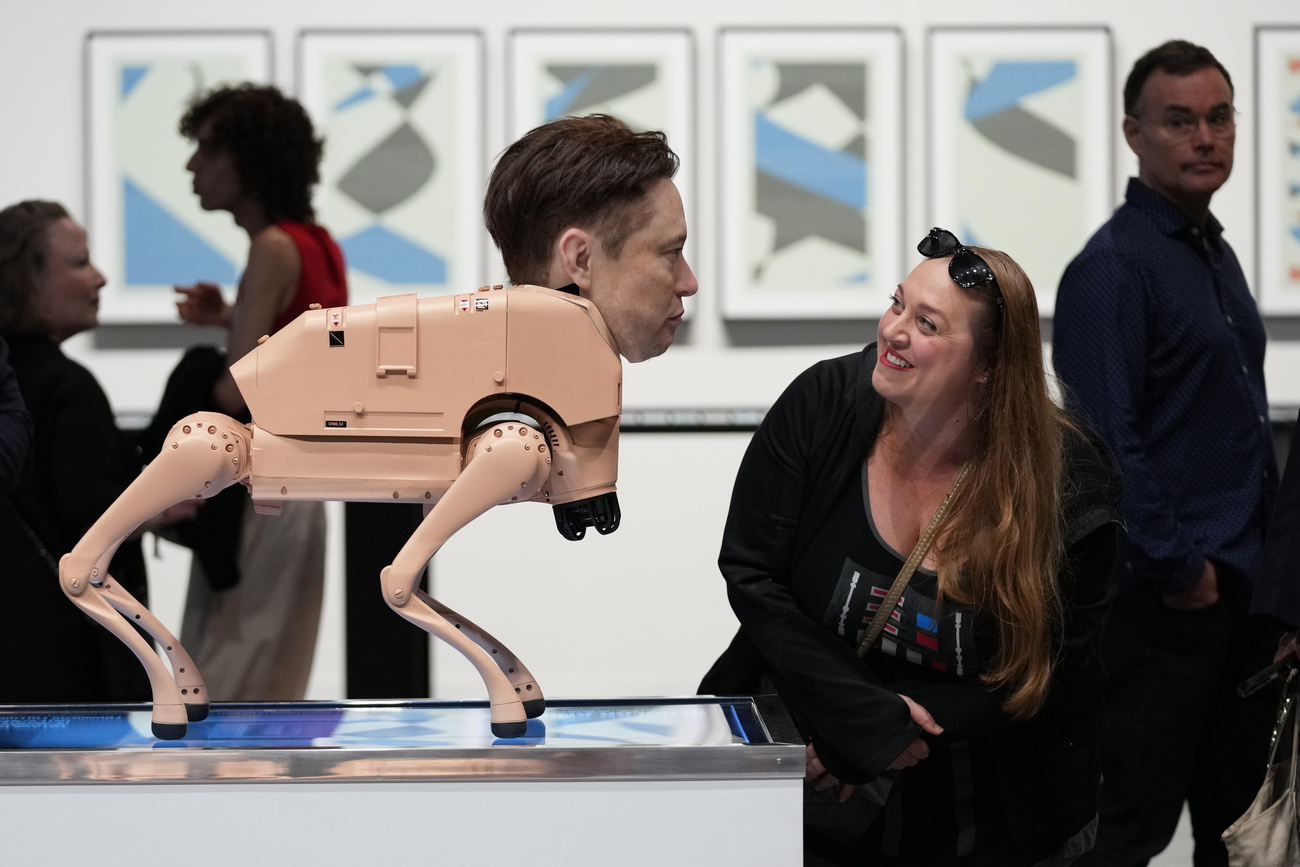 زائر ينظر إلى روبوت على هيئة إيلون ماسك في العمل التركيبي "حيوانات عادية" للفنان بيبل في معرض آرت بازل ميامي بيتش