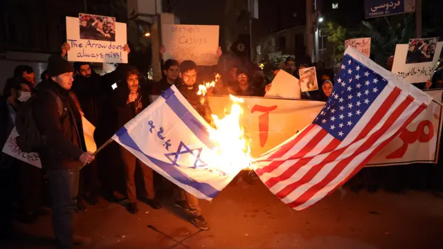 أحرق طلاب إيرانيون أعلام الولايات المتحدة وإسرائيل خلال احتجاج أمام السفارة البريطانية في طهران، إيران.
