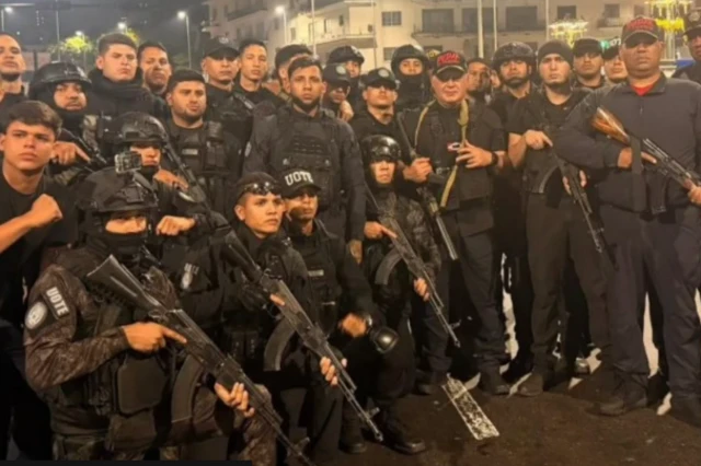 مجموعة من أفراد الشرطة في فنزويلا يرتدي جميعهم سترات شرطية سوداء وقبعات، وبعضهم ملثم بينما يحمل كل منهم سلاحاً.