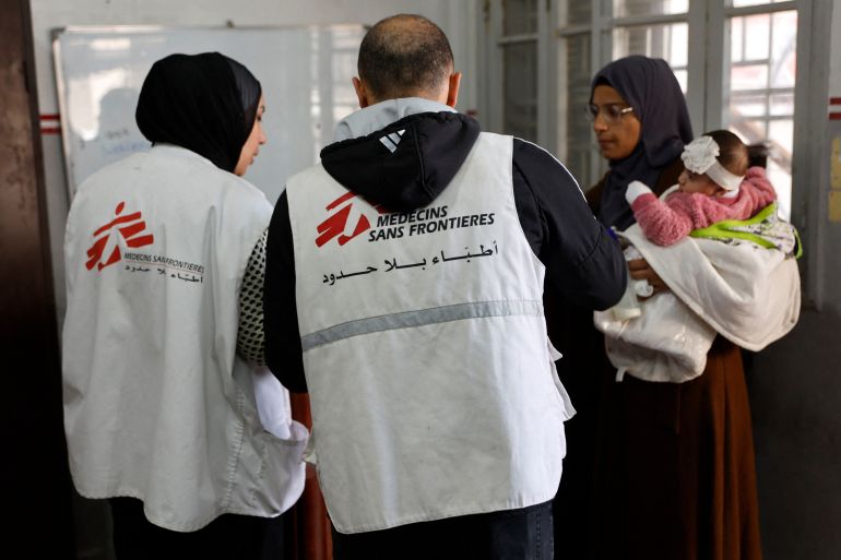 A Palestinian woman arrives with a child at the Doctors Without Borders or Medecins Sans Frontieres (MSF) clinic, in the al-Rimal neighborhood of Gaza City on new year's Eve, December 31, 2025.