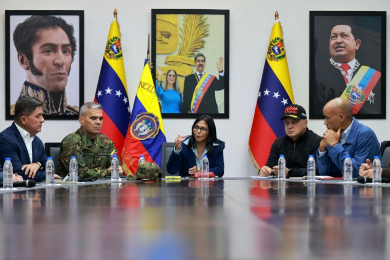 TOPSHOT - This handout picture released by the Miraflores Palace press office shows Venezuela's Vice-President Delcy Rodriguez (C) speaking next to Venezuelan Defense Minister Vladimir Padrino Lopez (2nd-L) and Venezuela's Minister of Interior Relations, Justice, and Peace, Diosdado Cabello (2nd-R) during a council of ministers meeting at the Vice Presidency headquarters in Caracas on January 4, 2026.
