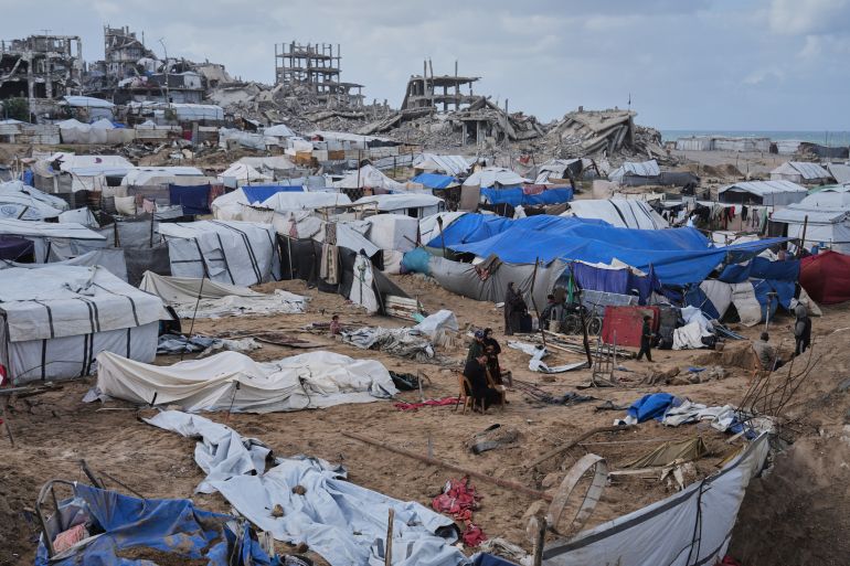 Palestinians inspect damaged tents at a displacement camp following an Israeli strike in Gaza City, Friday, Jan. 9, 2026. (AP Photo/Jehad Alshrafi)