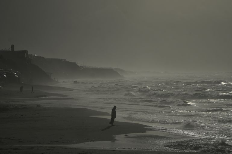 Palestinians walk along the beachfront amid stormy weather in Deir al-Balah, in the central Gaza Strip, Friday, Jan. 9, 2026. (AP Photo/Abdel Kareem Hana)