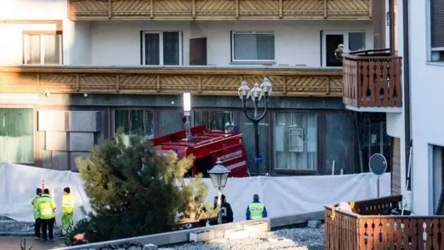 أفراد من الشرطة خارج المبنى الأبيض وفيه خشب بني اللون.