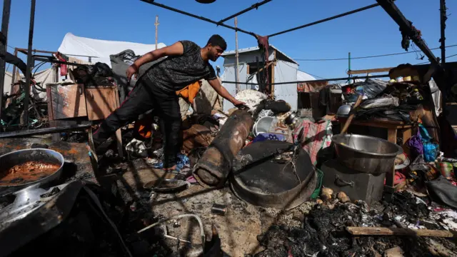 يتفقد فلسطينيون موقع غارة إسرائيلية استهدفت خياماً يوم السبت في خان يونس، جنوب قطاع غزة، في 31 يناير/كانون الثاني 2026. 
