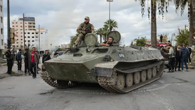 قوات الأمن السورية تقف فوق مركبة عسكرية بينما يتم نشر القوات بعد اندلاع اشتباكات خلال احتجاج قام به أفراد من الطائفة العلوية في مدينة اللاذقية، سوريا، 28 ديسمبر 2025.