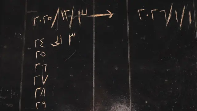 جدار مطلي باللون الأسود عليه تواريخ محفورة باللغة العربية