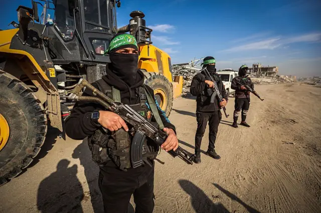 صورة بتاريخ 7 يناير/كانون الثاني، لمقاتلين من حركة حماس، أثناء مواصلتهم عمليات البحث لاستعادة جثة الرهينة الإسرائيلي الأخير، ران غفيلي، في حي زيتون بمدينة غزة، ويظهر مقاتلو الحركة ملثمين ومدججين بالسلاح، وُتغطي وجههم، وفي الحلفية ونش.