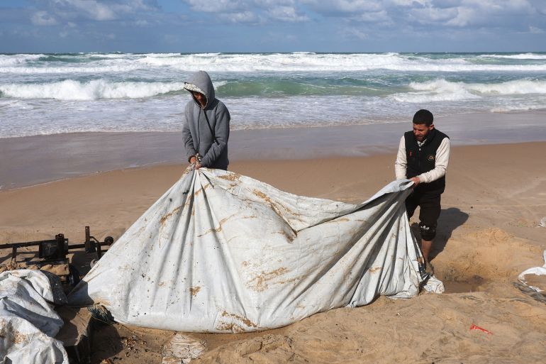 Displaced Palestinians pull out a collapsed tent at a beach tent camp, after it was flooded by rising seawater during a winter storm in Khan Younis, southern Gaza Strip, December 28, 2025. REUTERS/Ramadan Abed