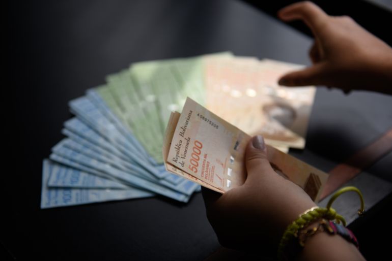 CARACAS, VENEZUELA - JUNE 20: A private bank employee counts the new banknotes of 10,000, 20,000 and 50,000 bolivares on June 20, 2019 in Caracas, Venezuela. Central Bank of Venezuela introduces three new banknotes of 10,000, 20,000 and 50,000 bolivares to cope with inflation which shows no sings of slowing down. Until 12 June 2019 the biggest bill was of 500 bolivares. The new largest banknote of 50,000 bolÌvares released today is equivalent to about 8 USD, more than the minimum wage of 40,000 bolÌvares a month (6,13 USD). (Photo by Carolina Cabral/Getty Images)