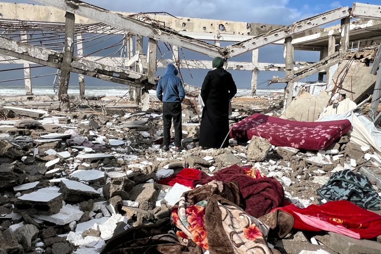 -أقارب الضحايا الثلاثة من عائلة حمودة يتفقدون الحطام بعد انهيار الجدار على الخيام بفعل الرياح الشديدة.