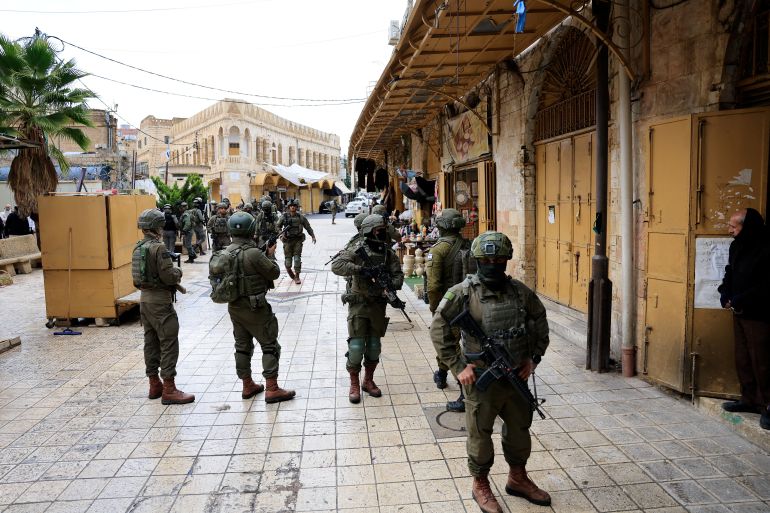 Israeli soldiers stand guard during a weekly settlers' tour in Hebron, in the Israeli-occupied West Bank, January 10, 2026. REUTERS/Mussa Qawasma