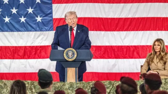الرئيس الأمريكي دونالد ترامب يتحدث أمام أعضاء الخدمة العسكرية وعائلاتهم في فورت براغ، كارولاينا الشمالية، الولايات المتحدة الأمريكية وتجلس على المنصة بجانبه السيدة الأولى ميلانيا ترامب
