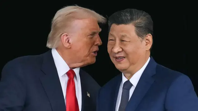 الرئيس الأمريكي دونالد ترامب يهمس في إذن الرئيس الصيني شي جين بينغ ويصافحان بعضهما البعض بعد محادثاتهما في بوسان في 30 أكتوبر/ تشرين الأول 2025.