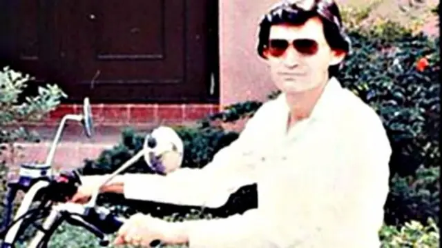 ميغيل أنخيل فيليكي غالاردو بقميص بياء على دراجة نارية ويرتدي نظارات للشمس