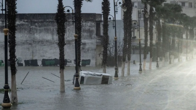 سيارة عالقة وسط مياه الفيضان بعد أن غمرت المياه المنازل في قصر الكبير بالمغرب، في 30 يناير/ كانون الثاني 2026.