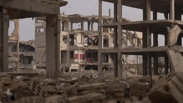 هياكل خرسانية لمبانٍ سكنية مدمرة، محاطة بالأنقاض، في جوبر، وهو حيّ يقع على مشارف دمشق