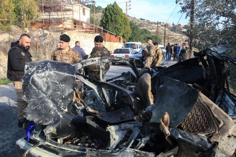 Lebanese army soldiers stand next to the wreckage of a car that was trageted in an Israli air strike near the southern Lebanese village of Mazraat al Qnaitra on December 22, 2025.