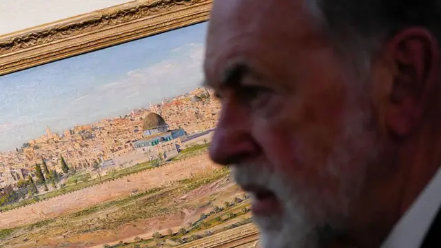 السفير الأمريكي لدى إسرائيل مايك هاكابي يشاهد لوحة زيتية للقدس خلال زيارة إلى مقر إقامة بيت هاناسي الرئاسي في القدس، في 15 سبتمبر 2025.