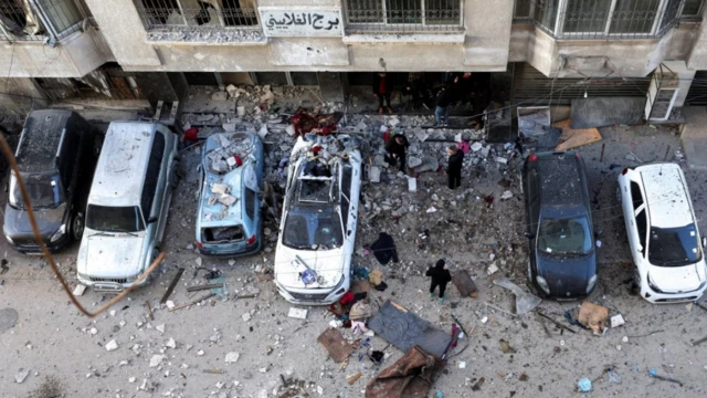 فلسطينيون يتفقدون موقع غارة إسرائيلية يوم السبت في مدينة غزة، 31 يناير/كانون الثاني 2026