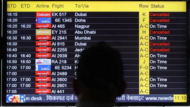 رجل يشاهد شاشة تعرض معلومات الرحلات الجوية في مطار إنديرا غاندي الدولي في نيودلهي، الهند، 2 مارس/آذار 2026.