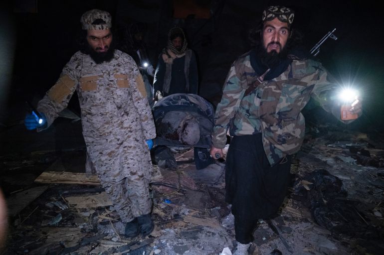 Taliban security personnel carry a body after Pakistani airstrikes allegedly hit the Secondary Rehabilitation Services Centre in Kabul on March 16, 2026. Heavy casualties were feared on Tuesday after Afghanistan accused Pakistan of hitting a treatment centre for drug addicts in the capital, Kabul, and killing civilians. Pakistan denied deliberately targeting the facility, instead saying it had conducted precision strikes on "military installations and terrorist support infrastructure". The Pakistani military has struck Kabul several times in recent weeks, as part of a conflict sparked by claims that the Taliban government has harboured extremists who have carried out attacks across the border. (Photo by Wakil KOHSAR / AFP)