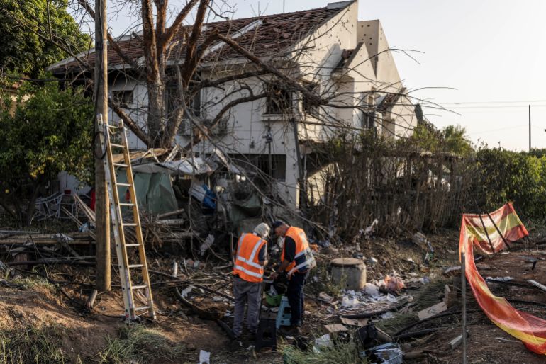 Electricians work at a house that was damaged by a rocket reportedly fired by Tehran-backed militant group Hezbollah in Haniel, near Kfar Yona in central Israel, on March 12, 2026.